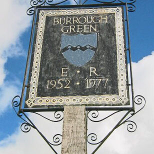 Village sign for Burrough Green with a shield and the dates 1952 and 1977.