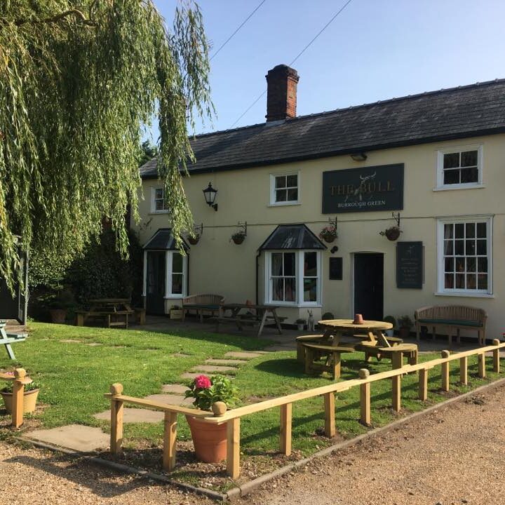 The Bull pub in Burrough Green with outdoor picnic tables on a grass lawn.